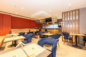 a restaurant with wooden tables and blue chairs at QUİ Hotel&SPA in Istanbul