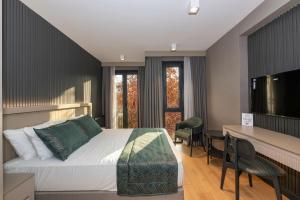 a bedroom with a bed and a desk with chairs at QUİ Hotel&SPA in Istanbul