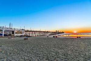 een uitzicht op een strand met een pier bij zonsondergang bij 5N-64 Beachfront On the Strand in Oceanside