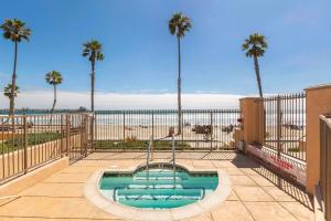 een zwembad met palmbomen en het strand bij 5N-64 Beachfront On the Strand in Oceanside
