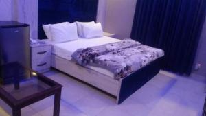 DargaiにあるHotel Comfort Innのベッドルーム1室(ベッド1台、ナイトスタンド、テーブル付)