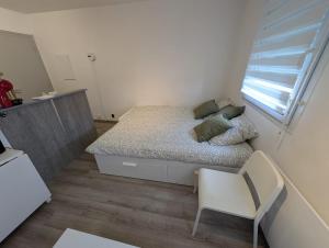 a small bedroom with a bed and a chair at City Break Arras in Arras
