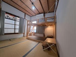 una stanza con un letto a castello e un tavolo di Edo Tokyo Sharehouse Long Stay Only, One month plus a Tokyo