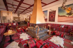 a living room with red couches and a fireplace at Valley Resort in Wadi Rum