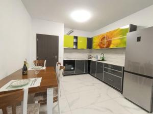 a kitchen with a wooden table and a refrigerator at Vitosha view Mladost apartment in Sofia