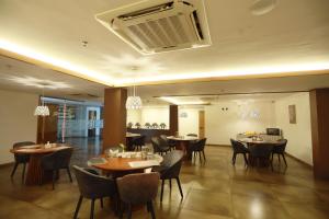 a restaurant with tables and chairs and a fan at Devalokam Edappal in Edappāl
