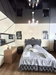 ein Schlafzimmer mit einem Bett und einem Kronleuchter in der Unterkunft La discrète romantique, appartement avec jacuzzi in Charavines