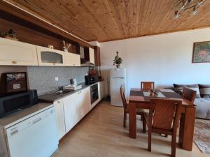 a kitchen and dining room with a table and a couch at Saphir apartment , Rhodopi Pearl Pamporovo in Pamporovo +10 photos