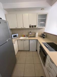 una piccola cucina con armadietti e elettrodomestici bianchi di Bright Mahane Yehuda 1 BR with Private Terrace a Gerusalemme