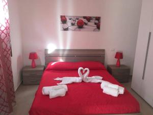カステッランマーレ・デル・ゴルフォにあるCasa fragolaのベッドルーム1室(赤いベッド1台、タオル付)
