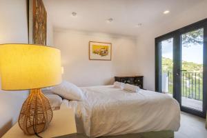 a bedroom with a bed and a lamp on a table at Cala Nostra Bea in Palafrugell +53 photos