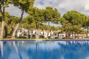 a swimming pool with trees and houses in the background at Cala Nostra Bea in Palafrugell