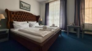 a bedroom with a large bed with two teddy bears on it at Altstadthotel Augsburg in Augsburg