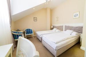 une chambre avec deux lits et une table et des chaises dans l'établissement Hotel Ambasadorski Rzeszów, à Rzeszów 29 autres photos