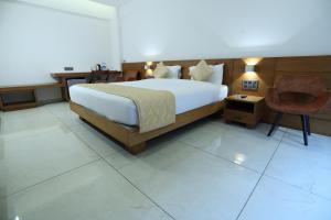 Un dormitorio con una cama grande y una silla en Devalokam Grand, en Edappāl