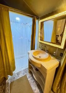 a bathroom with a sink and a mirror at Treasure Desert Camp in Merzouga