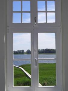 an open window with a view of the water at Wohnung Im Zweiten Obergeschoss Des Gutshauses in Neuenkirchen