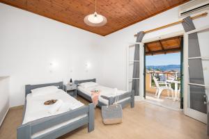 a bedroom with two beds and a balcony at Kavos Panorama Hotel in Kavos +21 photos