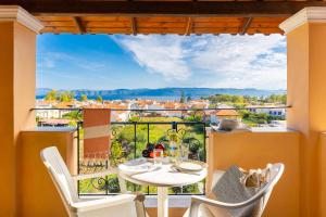 a balcony with a table and chairs and a view at Kavos Panorama Hotel in Kavos