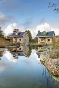 a house with a pond in front of it at Chão do Rio - Turismo de Aldeia in Seia