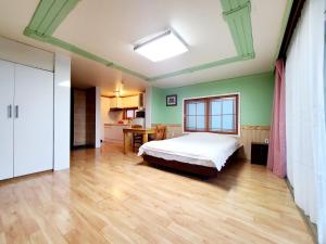 une chambre avec un lit et un parquet dans l'établissement Jeju Castle, à Seogwipo
