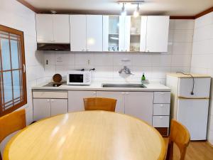 une cuisine avec une table en bois et un micro-ondes dans l'établissement Jeju Castle, à Seogwipo 3 autres photos