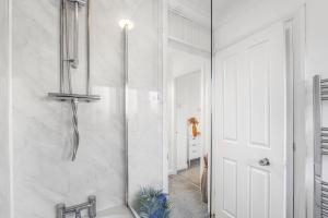 ein weißes Badezimmer mit Dusche und Waschbecken in der Unterkunft 4 Bedroom Elegant House Near Peterborough City Center with Free Parking - Angus Suites by Contractor Lettings in Peterborough + 60 Fotos