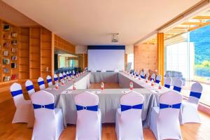 une grande salle de conférence avec une longue table et des chaises dans l'établissement Yangshuo County Rice Field Resort Hotel, à Yangshuo 122 autres photos