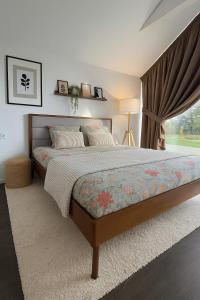ein Schlafzimmer mit großem Bett und Fenster in der Unterkunft Vila MurMur Papėje in Pape
