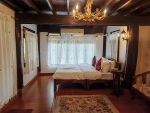 ein Schlafzimmer mit einem Bett und einem Kronleuchter in der Unterkunft Huen Tip Viman in Ban Nong Ho