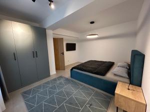 a bedroom with a bed and a cabinet at C&E Apart in Craiova