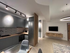 a kitchen with a stainless steel refrigerator and a tv at C&E Apart in Craiova