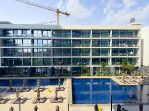 Ein Gebäude mit einem Kran vor einem Pool in der Unterkunft Grand Sapphire Hotel, Casino & Holiday Deluxe Residential Home in Iskele