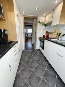 a kitchen with white cabinets and a tile floor at Bergnescht - Dein Wohnfühlort im Schwarzwald in Todtnauberg +19 photos