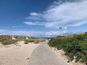 a path leading to a beach with a blue flag at 6 person holiday home in Dronningmølle-By Traum in Hornbæk