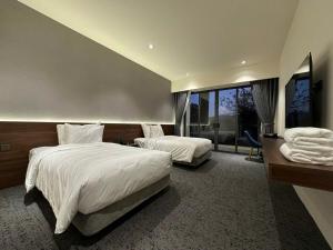 um quarto de hotel com duas camas e uma grande janela em Mountain Hill em Mai Sơn mais 18 fotografias