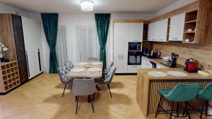 eine Küche und ein Esszimmer mit Tisch und Stühlen in der Unterkunft Regina Urban Stay VRT in Şelimbăr