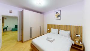 ein Schlafzimmer mit einem großen weißen Bett mit einem hölzernen Kopfteil in der Unterkunft Regina Urban Stay VRT in Şelimbăr
