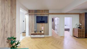 ein Wohnzimmer mit Holzwänden und einem TV an der Wand in der Unterkunft Regina Urban Stay VRT in Şelimbăr