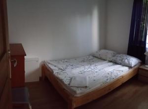 un petit lit dans une chambre avec un cadre en bois dans l'établissement Domek na Polesiu, à Wola Wereszczyńska