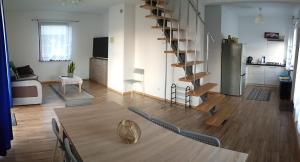 un salon avec une table et un escalier en colimaçon dans l'établissement Domek na Polesiu, à Wola Wereszczyńska