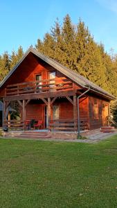 une grande cabane en rondins avec une véranda et une terrasse. dans l'établissement Domek na Polesiu, à Wola Wereszczyńska