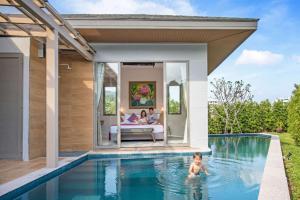 une famille dans la piscine d'une maison dans l'établissement Modern Eco Pool Villa Dalaa 7, à Kamala Beach