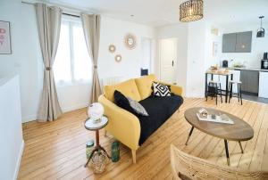 ルマンにあるLe Confort T2 tout équipé, proche Gare, Centre ville, Circuit des 24Hの黄色いソファとテーブルのあるリビングルーム +13枚の写真