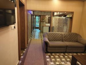 - un salon avec un canapé et un couloir dans l'établissement Sylora Meadows Private Pool Villa ,Vagamon, à Pīrmed