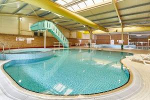 a large swimming pool in a large building at The Eden - Sleeps 8 Pet Friendly Free Wi-Fi With Patio & Hub Passes Camber Sands Cosy Spacious Modern 8 Berth Caravan in Camber