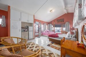 a large living room with red walls and a kitchen at Beachcomber Bay Guest House In South Africa in Margate