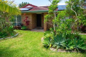 ein Haus mit einem Hof mit Pflanzen davor in der Unterkunft Serene Saltair in Redland Bay