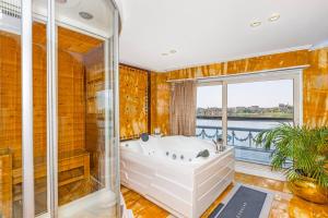 ein Bad mit einer Badewanne und einem Fenster in der Unterkunft Sonesta St George Nile Cruise - Aswan to Luxor 3 Nights from Friday to Monday in Assuan