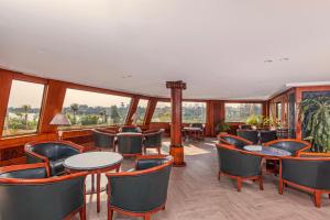 ein Restaurant mit Tischen und Stühlen und großen Fenstern in der Unterkunft Sonesta St George Nile Cruise - Aswan to Luxor 3 Nights from Friday to Monday in Assuan + 90 Fotos